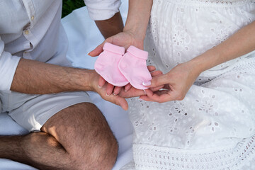 Pink socks for a newborn in the hands of a man and a woman
