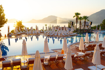 Pool with lounge chairs in resort hotel with mountain view