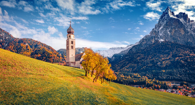 Majestic autumn view of snowy Petz peak. St. Valentin ( Kastelruth ) church in empty garden. Stuning autdoor scene of Kastelruth village, Dolomite Alps, Italy, Europe.