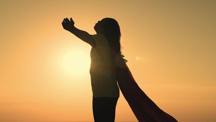 girl superhero with long hair red cape wind sunset. brave superhero ready help. superhero...
