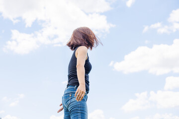 青空の下でポーズをとる女性