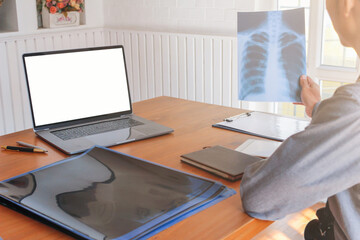 Doctors are examining X-rays of the patient's chest and pinpointing the site of malignant lung cancer and they advise patients on how to take care of their health during lung cancer treatment.