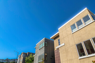 Three-storey houses against the clear blue sky background in San Francisco, CA