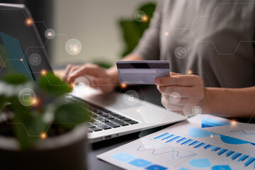 Close up shot of females hands holding credit card typing message on laptop for shopping online with technology icons.