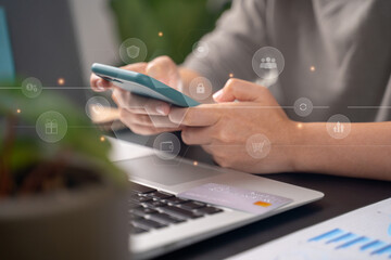 Close up shot of females hands typing on smart phone with technology icons at home office.