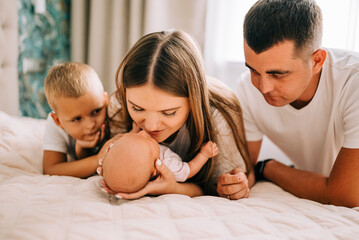 Newborn baby with happy parents and brother. Happy family. Healthy newborn baby with mom and dad. Mother, father and infant baby. Cute Infant girl and parents