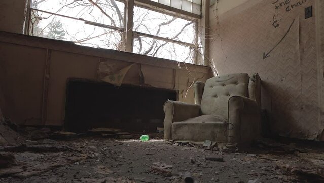 Slider Footage of a Dusty Old Chair Sitting under the Window in an Abandoned Office.  Decay, Haunted, Creepy, Eerie, Vandalized.