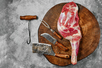 Raw lamb shoulder on butcher's cutting log with tools © boomeart
