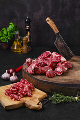 Chopping fresh beef meat on wooden chopping stump