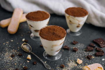 Italian dessert tiramisu in glass and eclairs with chocolate slices