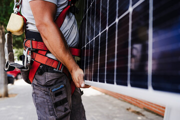 Technician carrying heavy solar panel