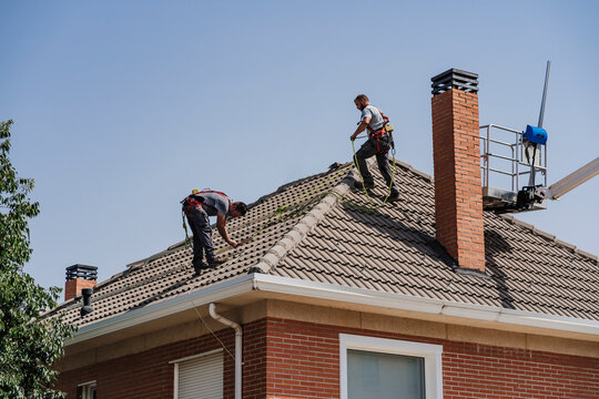 Technicians working on house rooftop