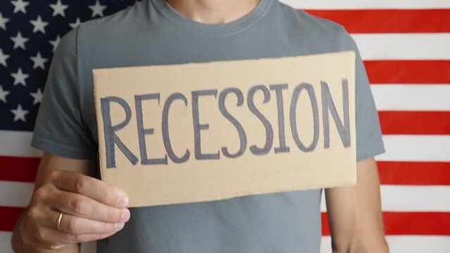 USA economic crisis, recession and and inflation, Man shows paper sheet with word recession against USA flag, Rising prices for consumer goods and services