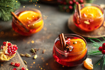 Christmas Mulled wine with different spices and fir tree bunch on rustic background. Winter time beverage concept. Copy space.