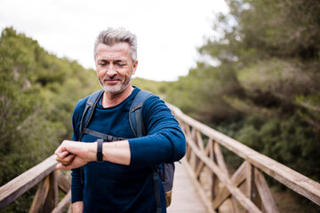 Smiling man checking time on wristwatch