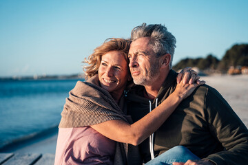 Happy mature couple spending time together at beach on sunny day