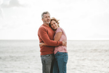 Loving mature couple hugging each other at beach on vacation