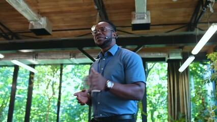 Video of a business conference meeting with an educator speaking to the people in the room. Cinematic footage representation of public speaking concepts and self improvement motivational summits