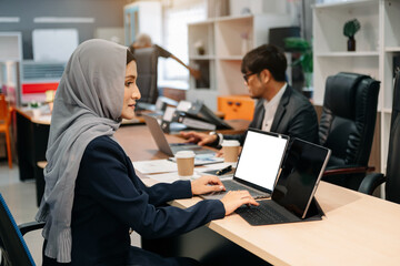 Businesswoman leading team meeting and using tablet and laptop computer with financial in coworking office.