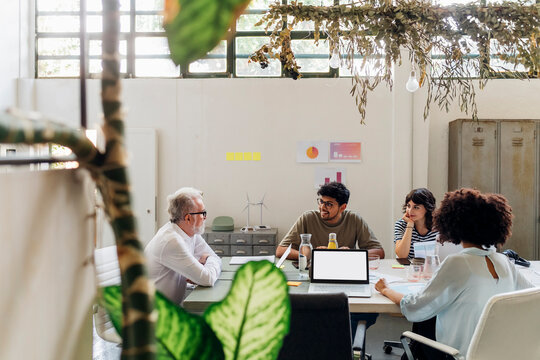 Coworkers Discussing With Each Other At Work Place