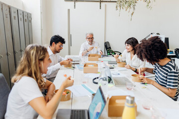 Colleagues having food together in lunch break at office
