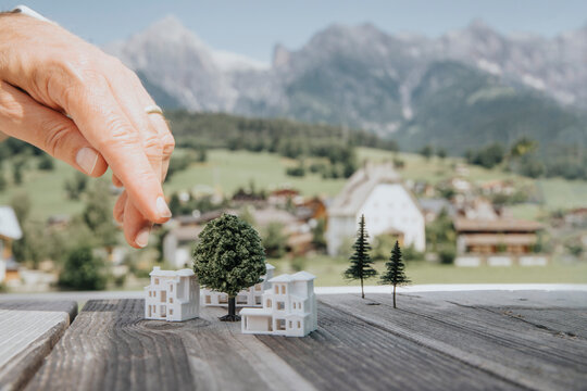 Hand of engineer pointing at building models on table