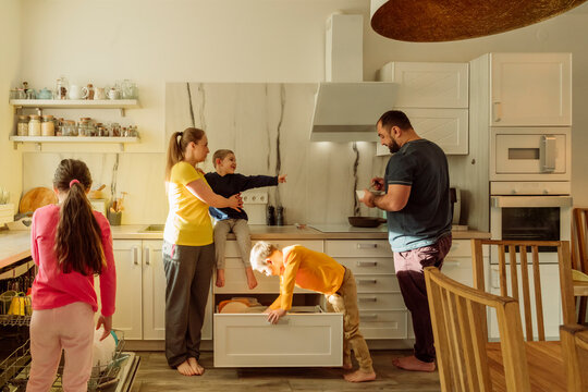 Mother and father with children in kitchen at home