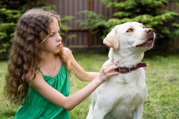 Girl adjusting dog's leash at back yard