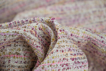Close up of textured fabric grey colour with pink, peach, silver and gold colours thread