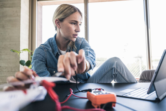 Woman examining drone through tablet PC in office