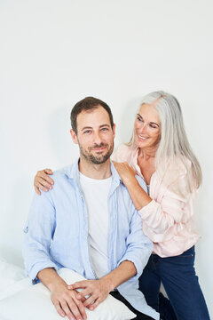 Happy man with mother spending time together at home
