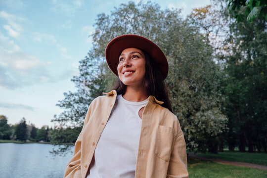 Smiling woman with hat in park