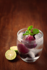 Close-Up of  fresh organic fruit jamun (Syzygium Cumini)  lemonade with lime and chilled water and ice 