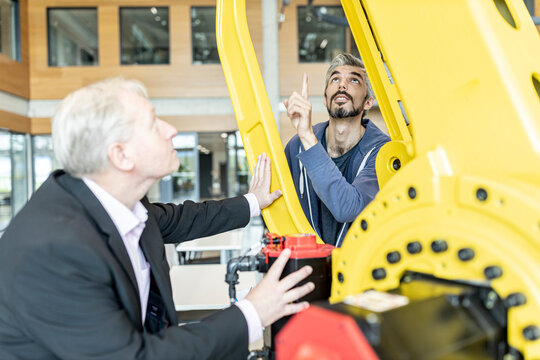 Senior customer getting advise on industrial robot from expert staff