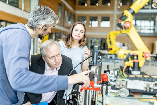 Senior customer getting advise on industrial robot from expert staff