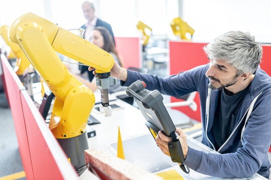 Industrial engineer working at industrial robot using digital control