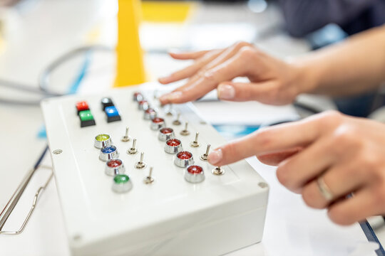 Hands of woman using switch box in industrial factory