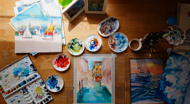 Watercolor painting and messy color palettes on table