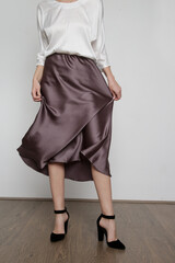 Series of studio photos of young female model wearing white silk satin batwing short sleeve blouse...