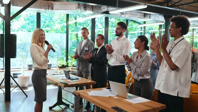 Video of a business conference meeting with an educator speaking to the people in the room. Cinematic footage representation of public speaking concepts and self improvement motivational summits