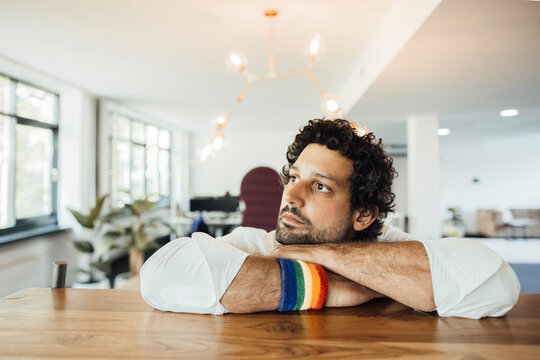 Thoughtful businessman leaning on desk at workplace