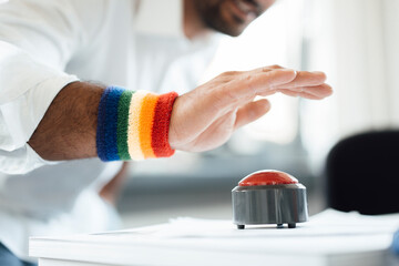 Businessman with hand poised on game show buzzer at office