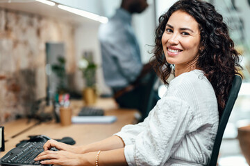Smiling businesswoman working on computer at office