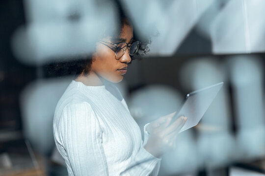 Thoughtful businesswoman using tablet PC in office