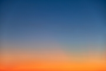 Fototapeta premium Orange and blue sunset sky gradient, copy space background. Red evening sky without clouds