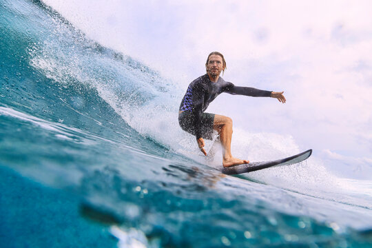 Man with surfboard surfing on sea