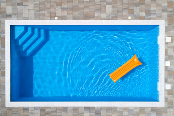 Yellow pool raft floating on water in swimming pool