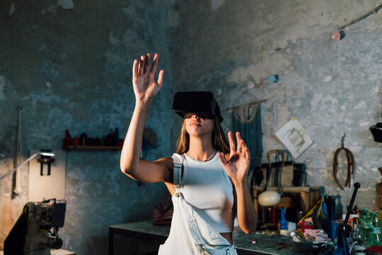 Young businesswoman wearing virtual reality simulator at workshop