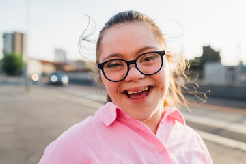 Happy teenage girl with down syndrome wearing eyeglasses