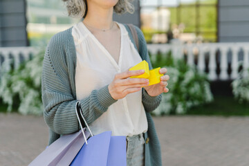 Hands of woman holding yellow gift box